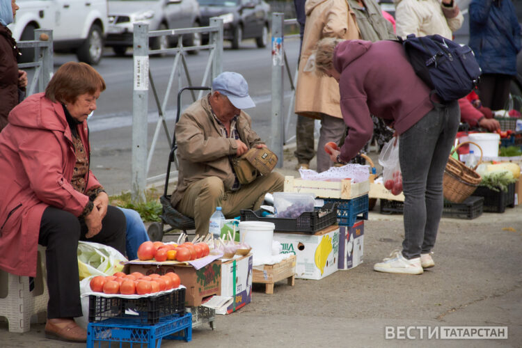пожилые люди продают овощи