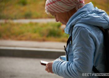 женщина идет с телефоном в руках